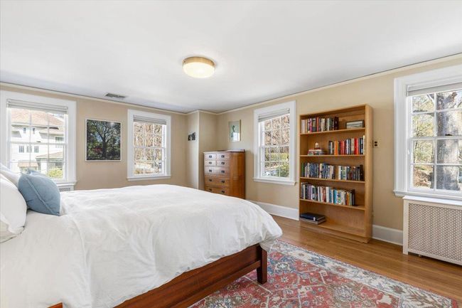Bedroom with baseboards, visible vents, radiator, wood finished floors, and crown molding | Image 15