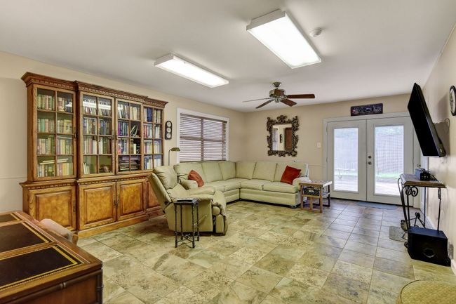 Living room with french doors, stone tile floors, and ceiling fan | Image 31