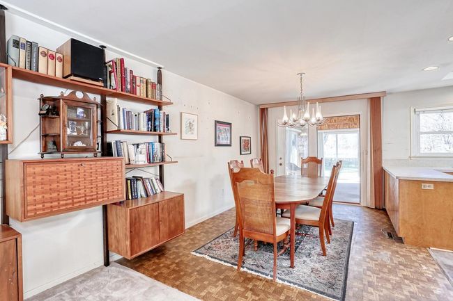 Dining space with baseboards and a notable chandelier | Image 6