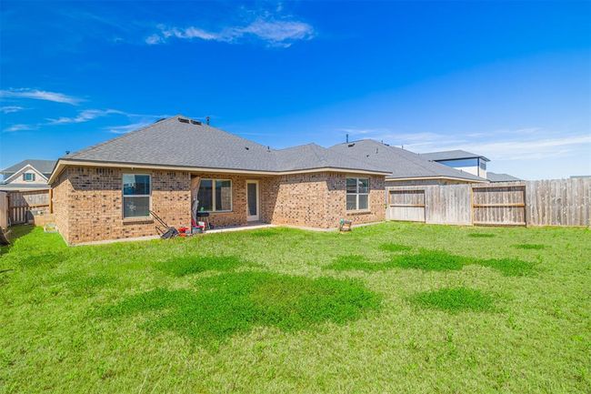 Enjoy outdoor living in the sizable backyard with a covered patio and sprinkler system. | Image 16