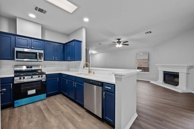 Kitchen featuring a peninsula, open floor plan, and a ceiling fan | Image 5