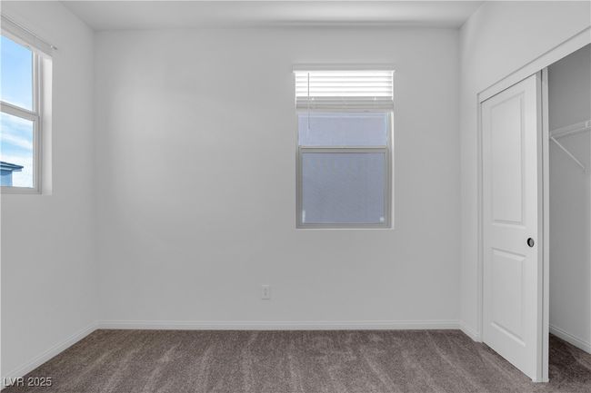 Unfurnished bedroom featuring a closet, dark colored carpet, and baseboards | Image 18