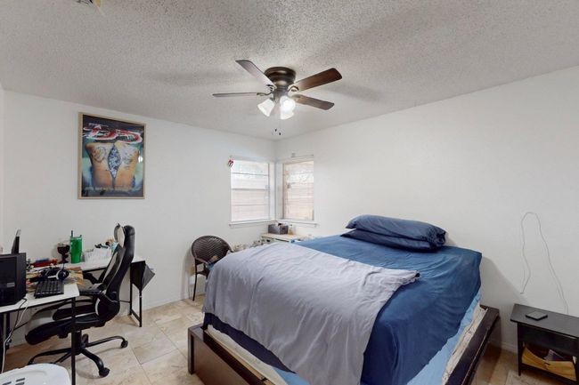 Bedroom featuring baseboards, a textured ceiling, and a ceiling fan | Image 25