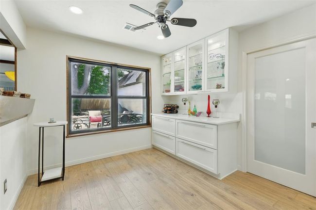 The breakfast room showcases a butlers pantry with quartz counters and deep drawers, a ceiling fan and recessed lighting. | Image 8