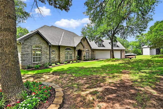 View of front facade with brick siding, a garage, a front lawn, and a shingled roof | Image 6