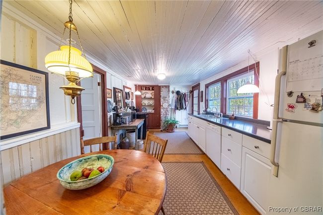 Dining area with wood walls, wooden ceiling, and built in shelves | Image 11