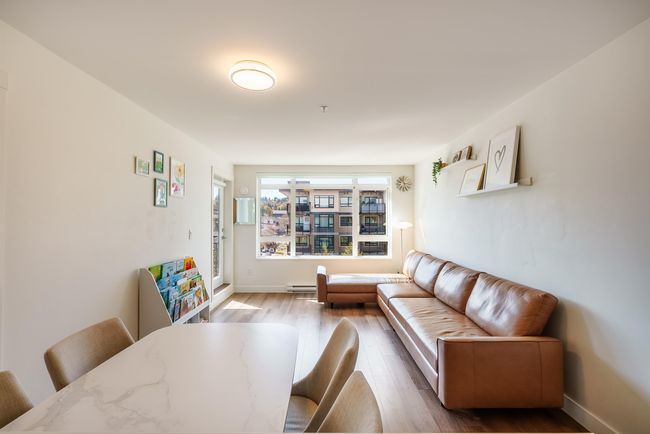 Living area featuring wood finished floors and baseboard heating | Image 5