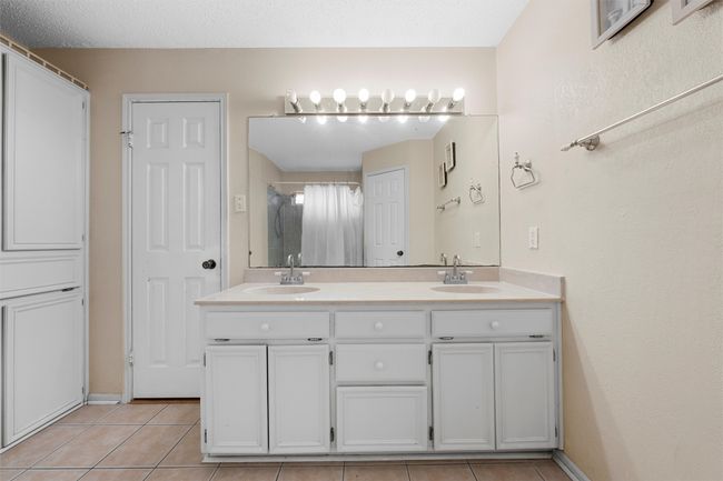 Bathroom featuring double vanity, tile patterned floors, and a shower with shower curtain | Image 11