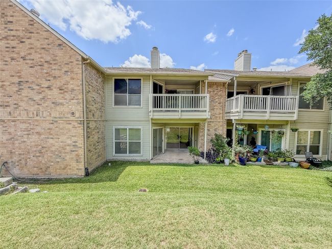 Back of house with a chimney, a lawn, brick siding, and a balcony | Image 28