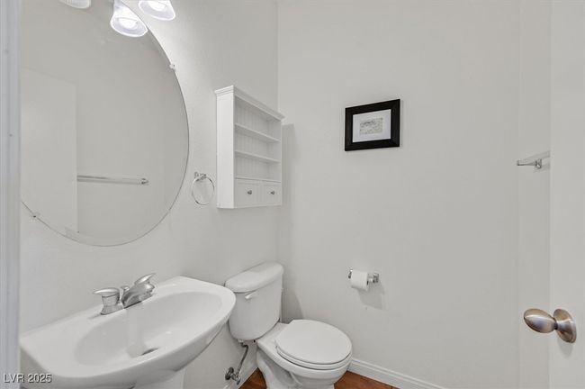 Half bathroom with a sink, baseboards, toilet, and wood finished floors | Image 14