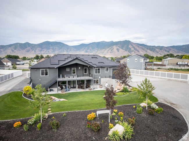 Rear view of property with stairs, a patio area, a fenced backyard, roof mounted solar panels, and a deck with mountain view | Image 94