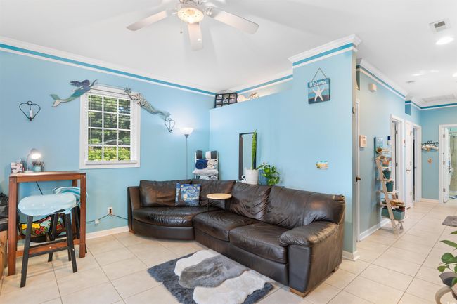 Tiled living area featuring ornamental molding, baseboards, and a ceiling fan | Image 8