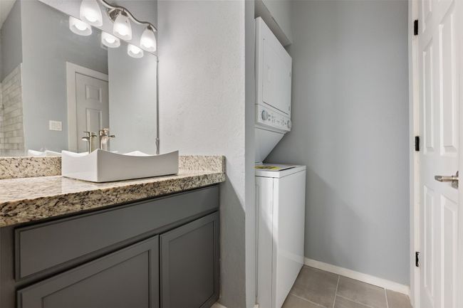 Bathroom featuring vanity, tile patterned floors, baseboards, and stacked washer / drying machine | Image 18