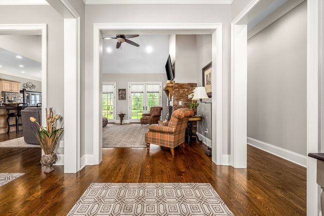 The entrance foyer, adorned with gleaming hardwood floors, sets a welcoming tone as it seamlessly connects to the home's main living areas. | Image 33