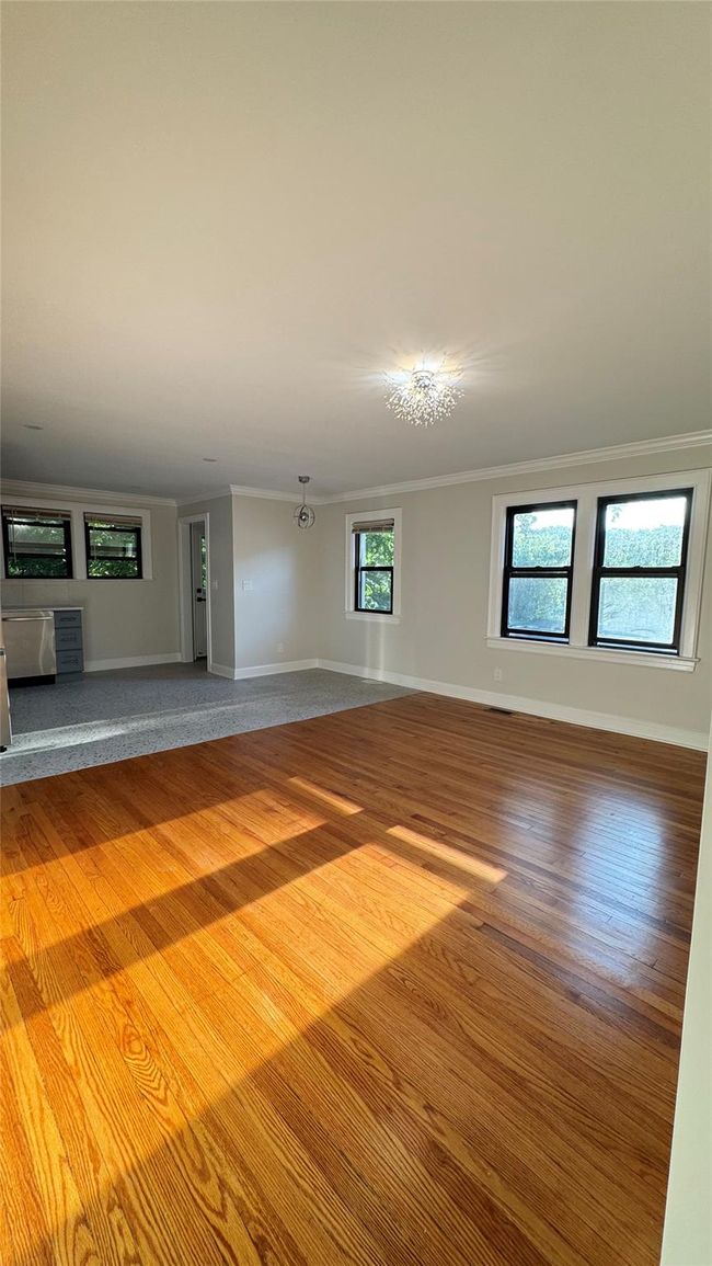 Unfurnished living room featuring ornamental molding and wood finished floors | Image 19