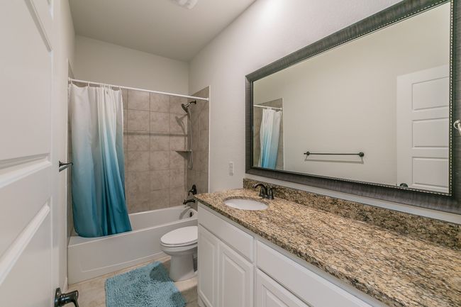 Bathroom with shower / bath combo with shower curtain, toilet, vanity, and tile patterned flooring | Image 34