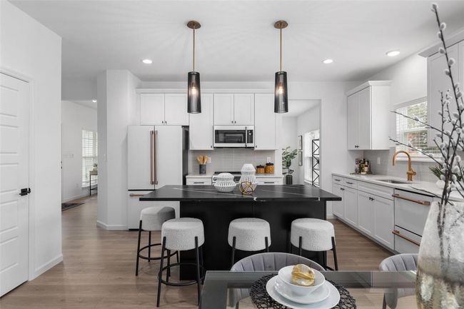 Kitchen featuring decorative backsplash, white appliances, and a center island | Image 25