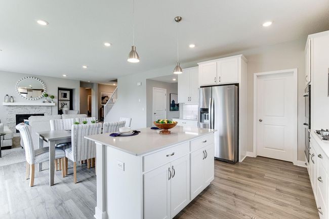 The signature kitchen in the Jordan floorplan is beautifully designed & includes quartz countertops, tile backsplash, double wall ovens & a huge walk-in pantry. The kitchen is a chef's dream & provides ample space for your culinary needs. | Image 9