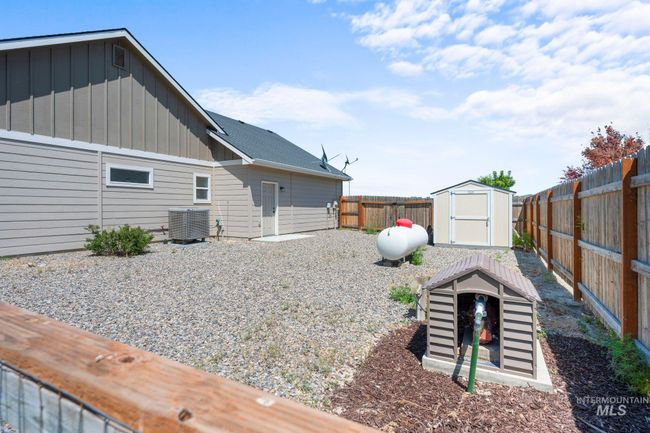 Fenced backyard with a storage unit | Image 39