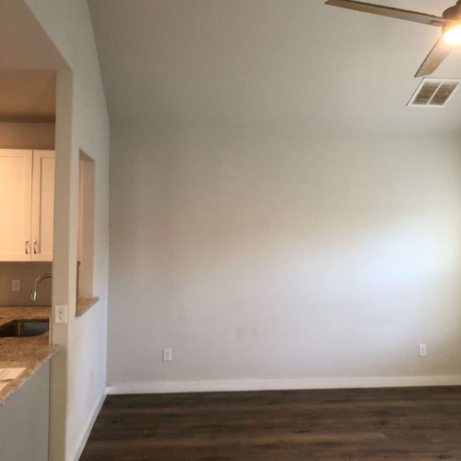 Unfurnished dining area with a sink, dark wood-style flooring, baseboards, and ceiling fan | Image 5