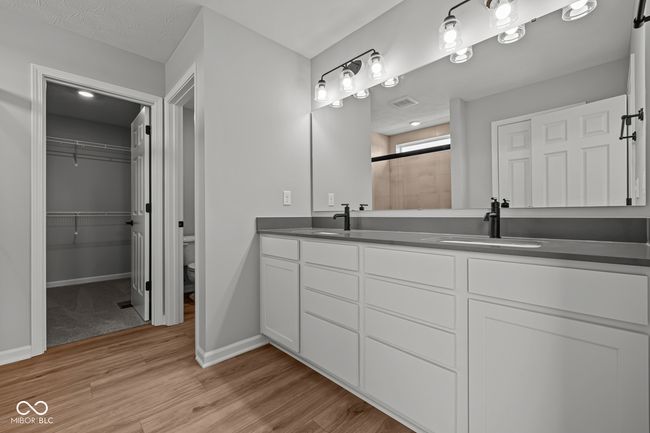 full bath featuring baseboards, a sink, tiled shower, and wood finished floors | Image 23