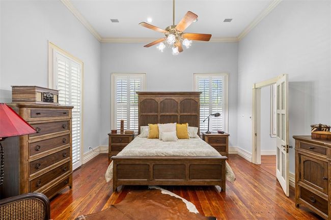 Generously-sized primary suite with elegant hardwood floors and ample natural light. | Image 12