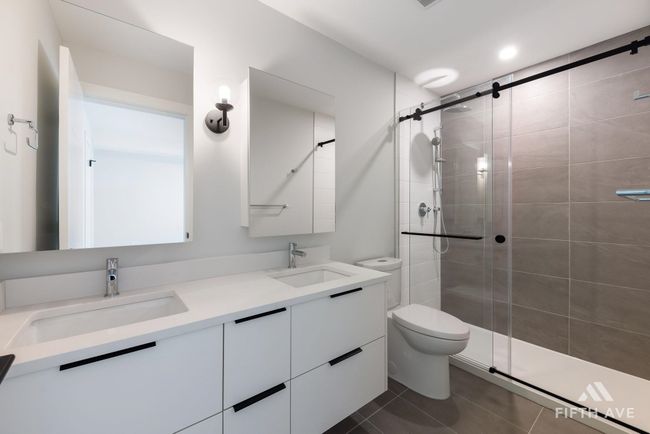 Bathroom featuring a shower stall, double vanity, and tile patterned flooring | Image 23