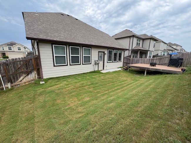 Rear view of house featuring a wooden deck and roof with shingles | Image 13