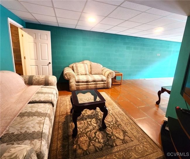 Living room with tile walls and a paneled ceiling | Image 31
