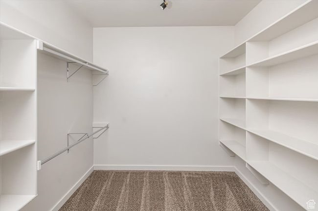 Walk in closet featuring dark carpet | Image 25