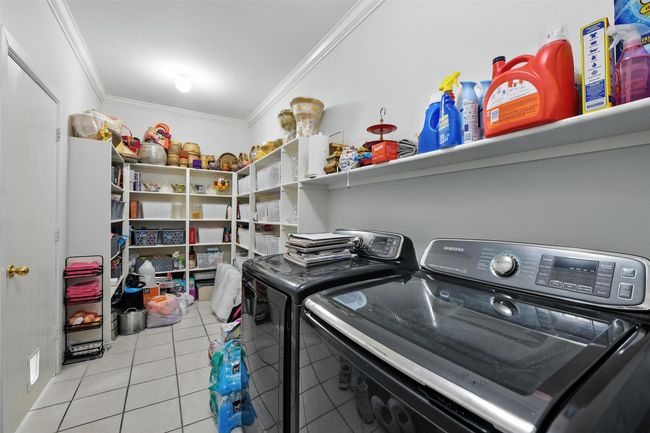 Laundry area featuring crown molding, washing machine and clothes dryer, and light tile patterned flooring | Image 28