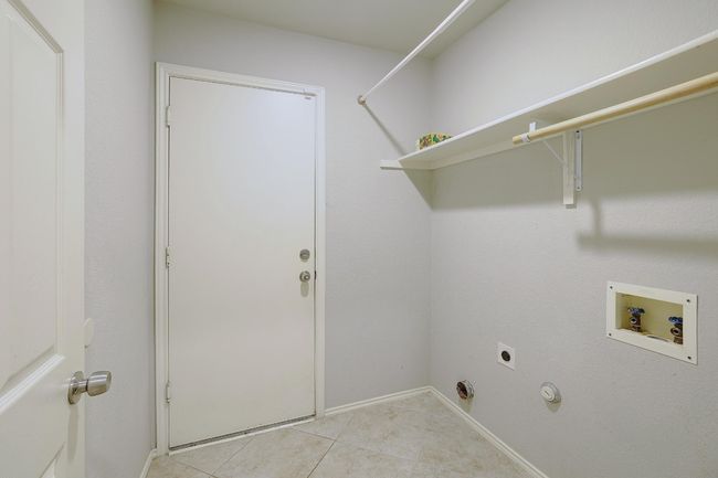 Washroom featuring washer hookup, hookup for an electric dryer, and light tile patterned floors | Image 23