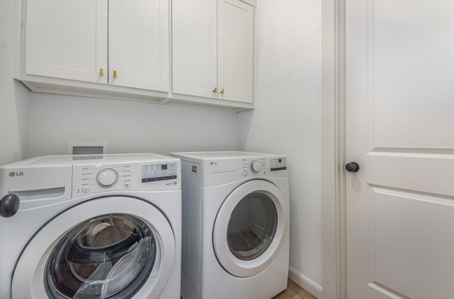 Laundry area featuring washing machine and dryer and cabinet space | Image 32
