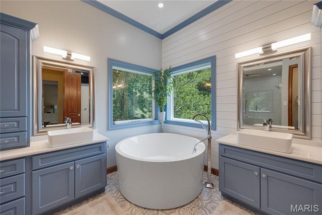 Full bath featuring vanity, a freestanding tub, ornamental molding, tile patterned flooring, and wood walls | Image 23