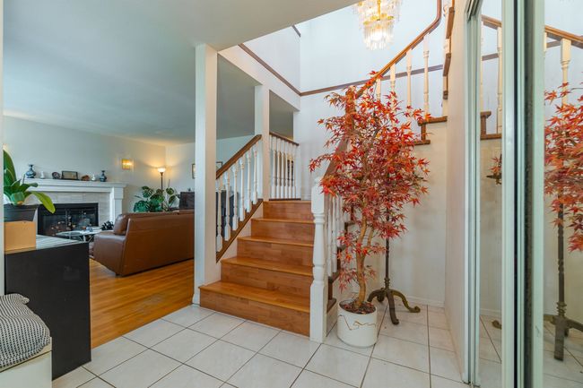 Stairway featuring tile patterned floors, a chandelier, and a high end fireplace | Image 4