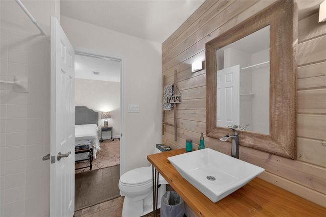 Bathroom featuring vanity, connected bathroom, wooden walls, a shower with curtain, and tile patterned flooring | Image 12