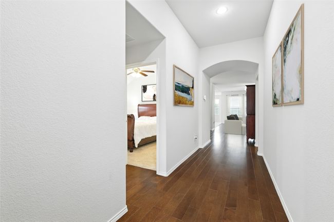 Corridor with arched walkways, dark wood-style floors, and baseboards | Image 4