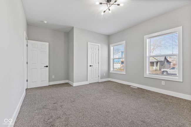Main level BR or Office with carpet, baseboards, an inviting chandelier, and a closet | Image 14