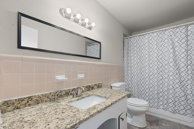 Full bathroom featuring tile walls, vanity, and a wainscoted wall | Image 14