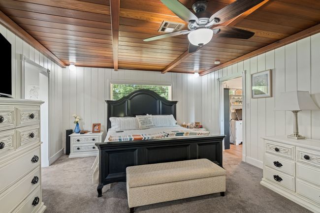 Bedroom with wood ceiling, light colored carpet, and a ceiling fan | Image 16