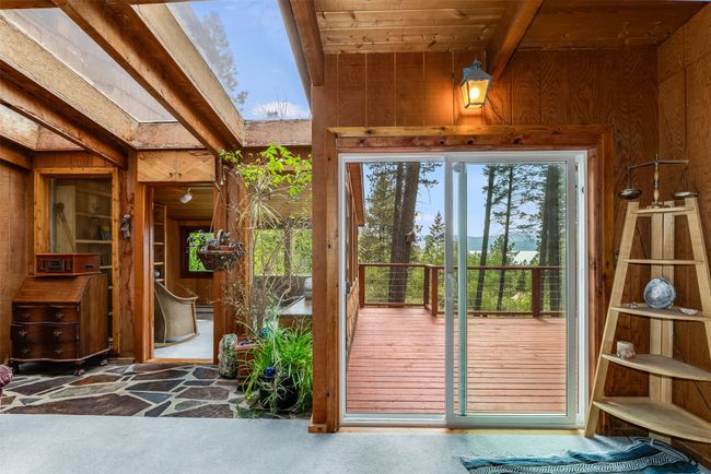 Doorway with wooden walls, a skylight, carpet flooring, and wooden ceiling | Image 13