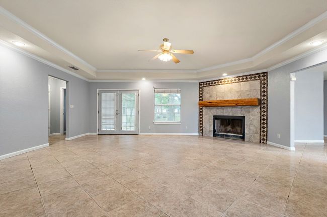 living room featuring crown molding, a ceiling fan, and a fireplace. | Image 9
