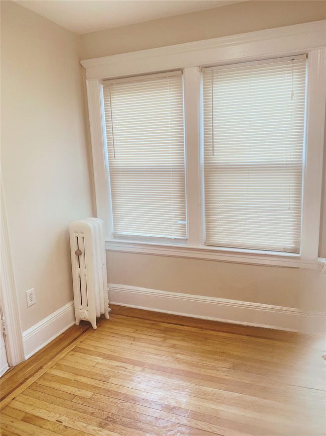 Empty room featuring radiator and light wood-style flooring | Image 10