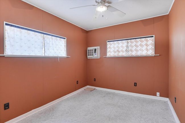 Spare room with a wall mounted air conditioner, a ceiling fan, and baseboards | Image 10