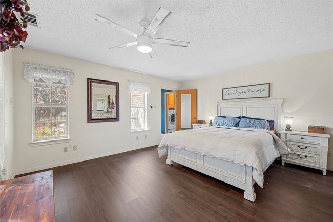 Bedroom with a textured ceiling, dark wood-type flooring, and baseboards | Image 17