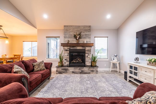 Living room with lofted ceiling, a stone fireplace, and recessed lighting | Image 20