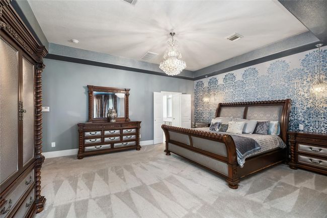 Wake up each morning in a space that feels more like a private getaway than a bedroom. Whether you're unwinding in the cozy sitting area with a book or enjoying the calm ambiance under the beautifully detailed tray ceiling, this suite offers room to relax, recharge, and truly feel at home. | Image 14