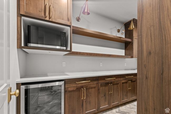 Kitchen featuring wine cooler, open shelves, and light countertops | Image 17