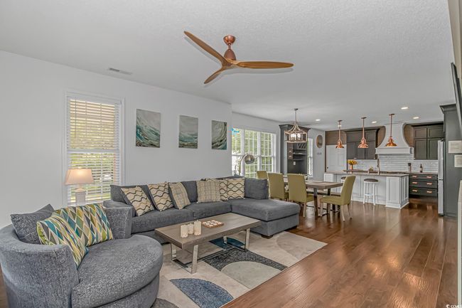 Living area featuring a ceiling fan, dark wood-style flooring, and recessed lighting | Image 5