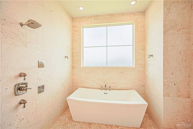 Bathroom with a freestanding bath, limestone walls, and tile patterned flooring | Image 11